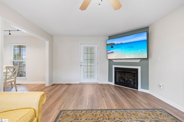 330 Split Oak Ln, Inman, SC 29349 - unfurnished living room featuring wood finished floors, a ceiling fan, baseboards, and a glass covered fireplace