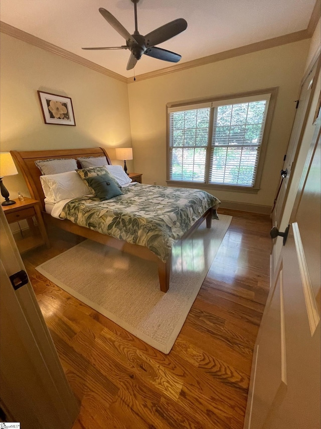 bedroom featuring ornamental molding, wood finished floors, and ceiling fan