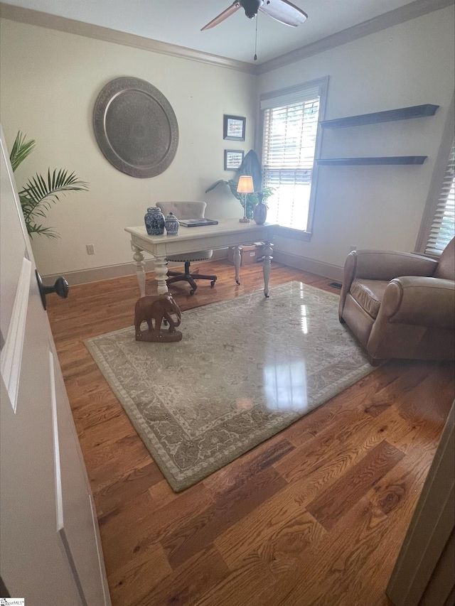 office space featuring baseboards, wood finished floors, ceiling fan, and crown molding