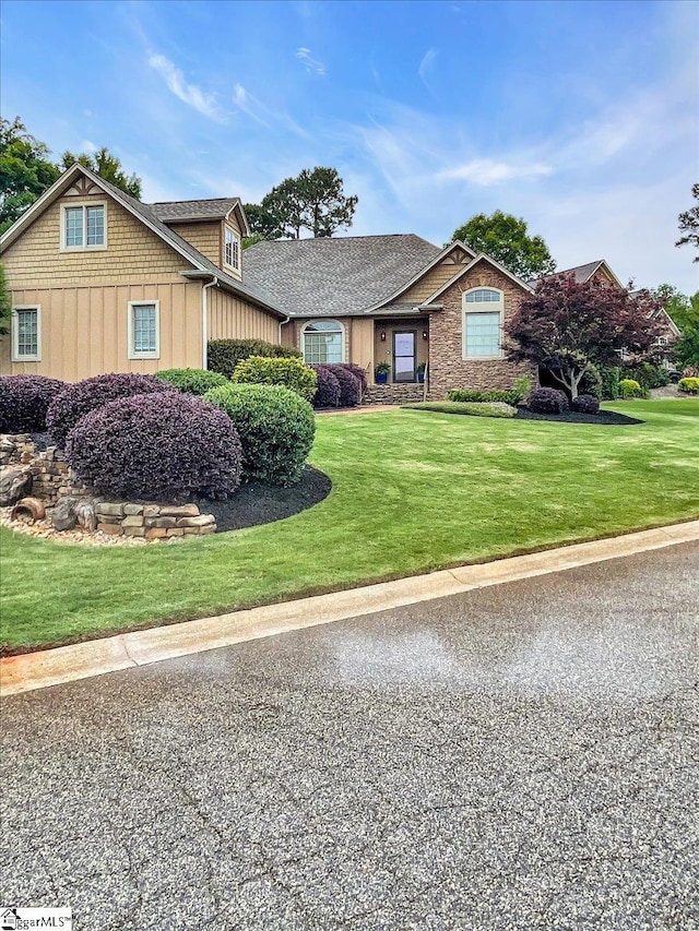 view of front of house with board and batten siding and a front lawn