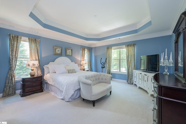 bedroom with a tray ceiling, crown molding, carpet floors, and baseboards