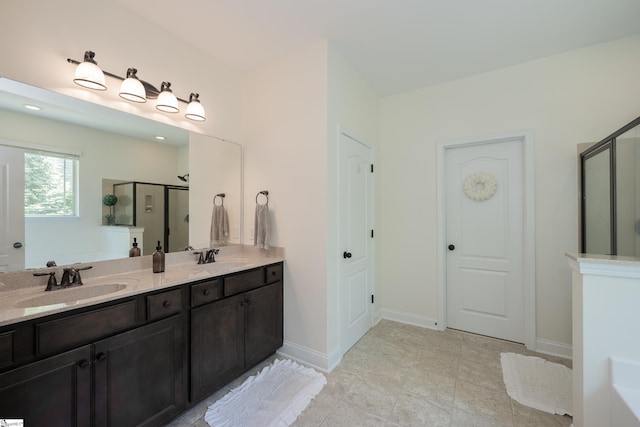 full bathroom featuring a stall shower, double vanity, and baseboards