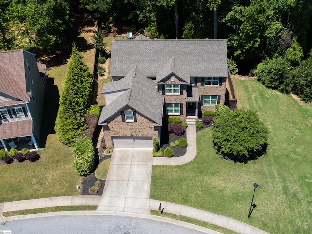 view of front of property featuring concrete driveway, a garage, a front yard, and stone siding