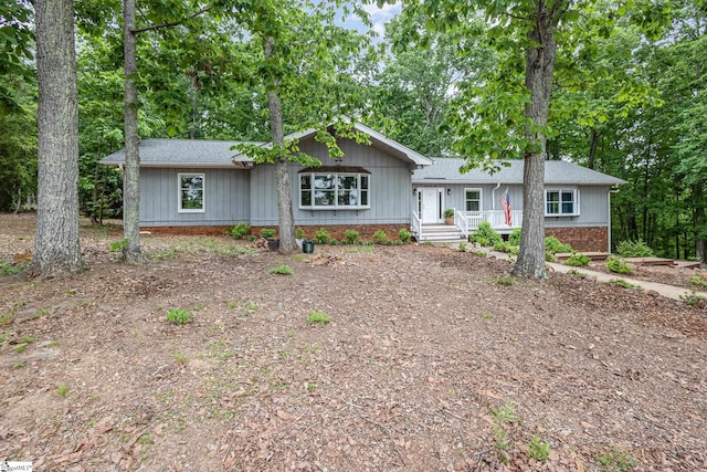 single story home featuring a shingled roof and covered porch