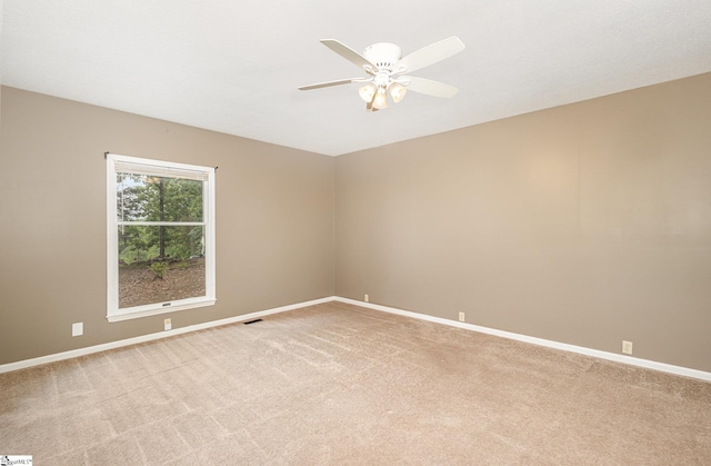 spare room with light carpet, ceiling fan, and baseboards