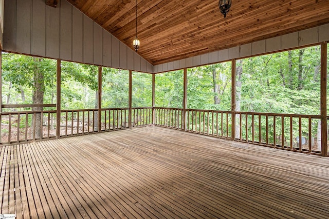 unfurnished sunroom with lofted ceiling and a view of trees