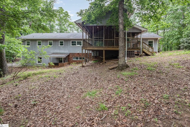 back of house featuring a sunroom and stairway