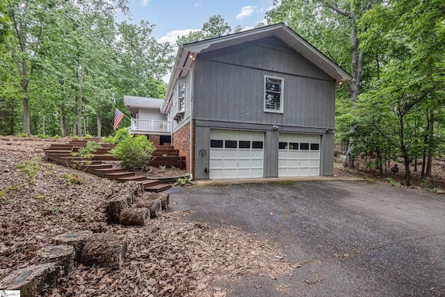 view of home's exterior with stairway, asphalt driveway, and an attached garage
