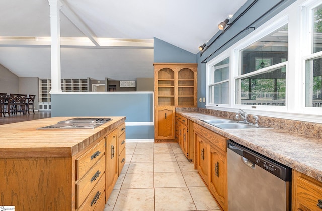 kitchen featuring appliances with stainless steel finishes, vaulted ceiling, a sink, butcher block countertops, and brown cabinetry