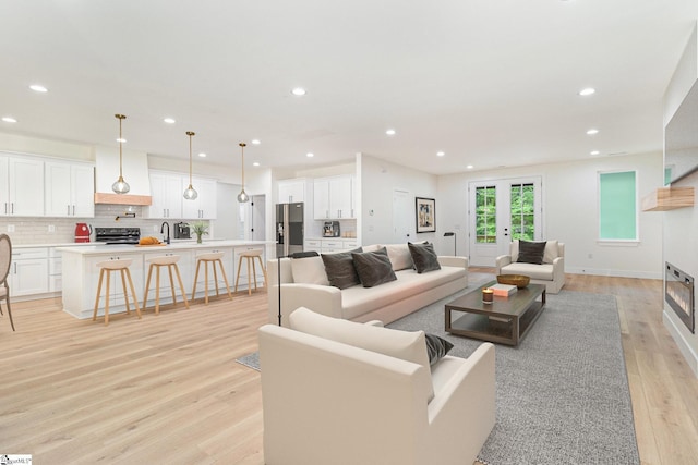 living room with light wood-type flooring and recessed lighting