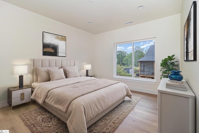 bedroom featuring light wood finished floors, baseboards, and recessed lighting