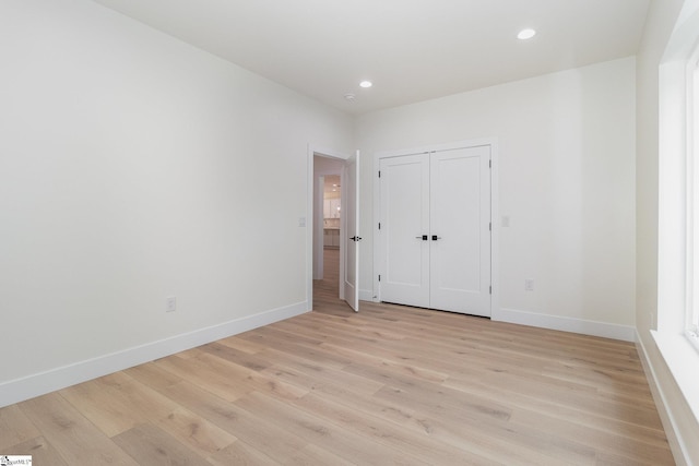empty room featuring light wood-style floors, baseboards, and recessed lighting