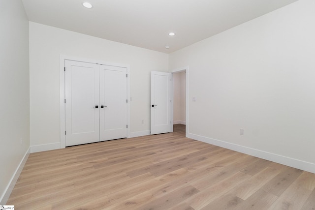 unfurnished bedroom featuring light wood-type flooring, baseboards, and recessed lighting