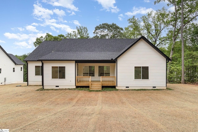 rear view of property with crawl space, covered porch, and a shingled roof
