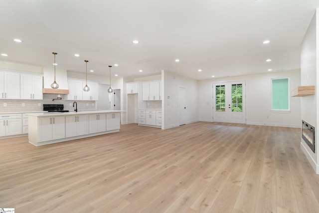 unfurnished living room with light wood-type flooring, recessed lighting, and baseboards