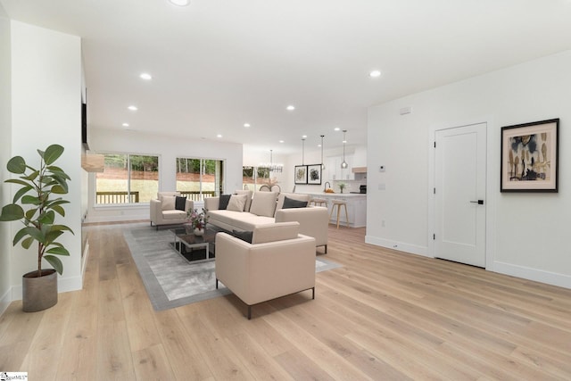 living room featuring light wood-style flooring, baseboards, and recessed lighting