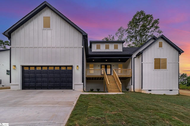 modern farmhouse with board and batten siding, crawl space, an attached garage, a lawn, and driveway