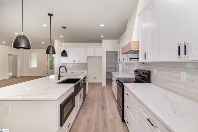 kitchen with black appliances, light wood-style flooring, white cabinets, recessed lighting, and tasteful backsplash