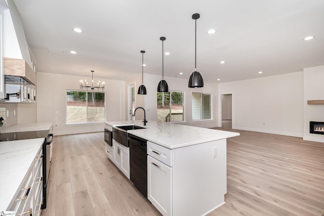 kitchen with electric stove, dishwasher, light wood-style flooring, a sink, and a chandelier