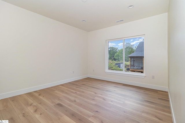 spare room with baseboards, light wood-type flooring, and recessed lighting