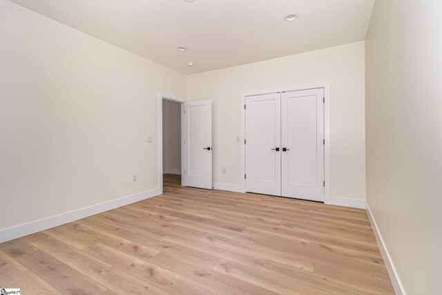 unfurnished bedroom featuring light wood-style flooring, baseboards, and recessed lighting