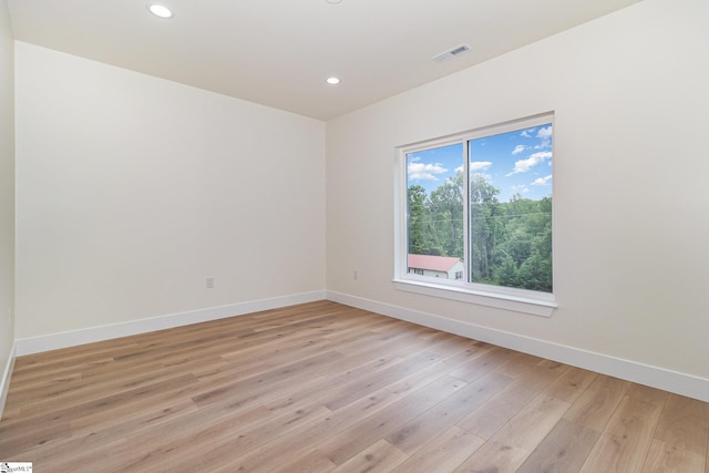 empty room featuring baseboards, light wood finished floors, and recessed lighting
