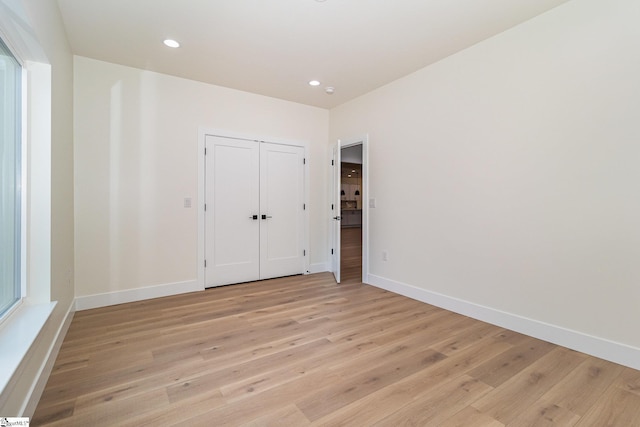 unfurnished bedroom featuring light wood-style flooring, baseboards, and recessed lighting