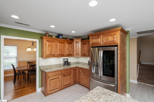 426 Isaqueena Dr, Greer, SC 29651 - kitchen featuring stainless steel fridge, crown molding, light stone countertops, brown cabinetry, and baseboards