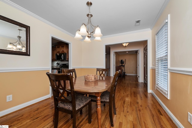 426 Isaqueena Dr, Greer, SC 29651 - dining space featuring a chandelier, wood finished floors, crown molding, and baseboards