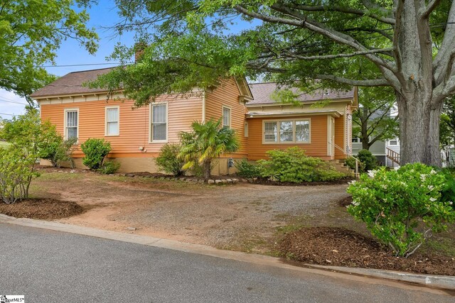 413 W Market St, Anderson, SC 29624 - view of front of property with a shingled roof, a chimney, and dirt driveway