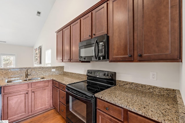 11 Penrith Ct, Simpsonville, SC 29681 - kitchen with black appliances, a sink, vaulted ceiling, light stone countertops, and light wood finished floors