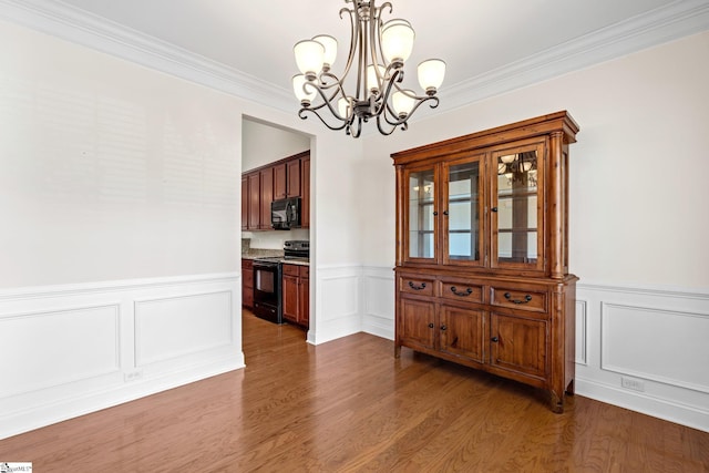 11 Penrith Ct, Simpsonville, SC 29681 - dining room with a chandelier, wainscoting, wood finished floors, crown molding, and a decorative wall