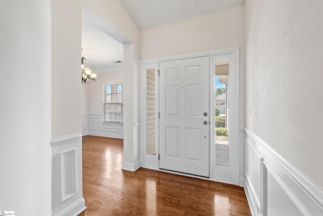 11 Penrith Ct, Simpsonville, SC 29681 - foyer entrance featuring a wainscoted wall, a chandelier, wood finished floors, and a decorative wall