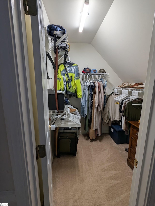 spacious closet with light colored carpet and vaulted ceiling