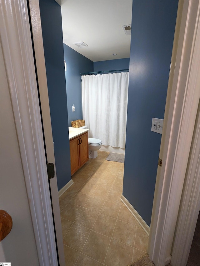 bathroom featuring toilet, tile patterned floors, vanity, baseboards, and a shower with curtain
