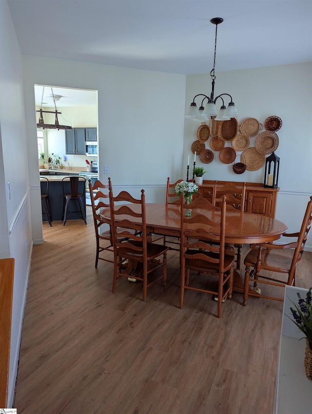 dining room with a chandelier and light wood-type flooring