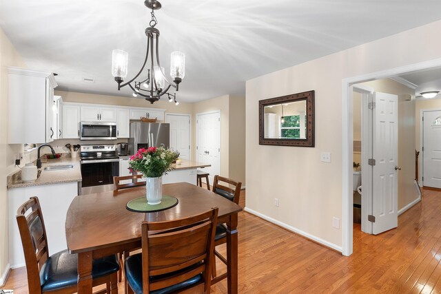 26 Willow Oak Ct, Simpsonville, SC 29681 - dining space featuring a chandelier, light wood-style floors, and baseboards