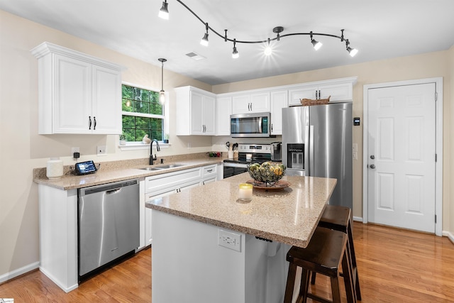 26 Willow Oak Ct, Simpsonville, SC 29681 - kitchen with appliances with stainless steel finishes, a sink, white cabinets, a kitchen breakfast bar, and light wood finished floors