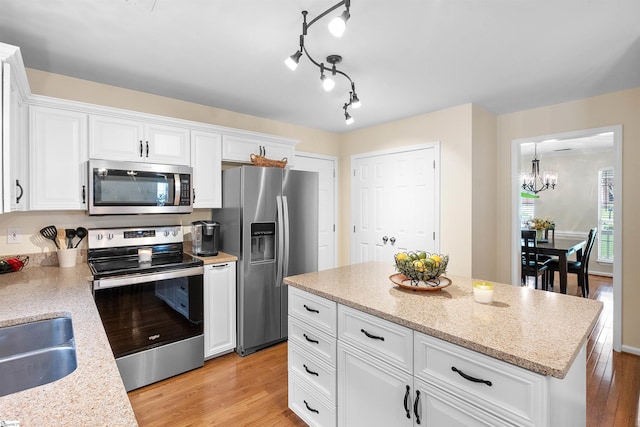 26 Willow Oak Ct, Simpsonville, SC 29681 - kitchen with appliances with stainless steel finishes, a chandelier, light wood-style floors, a sink, and white cabinetry