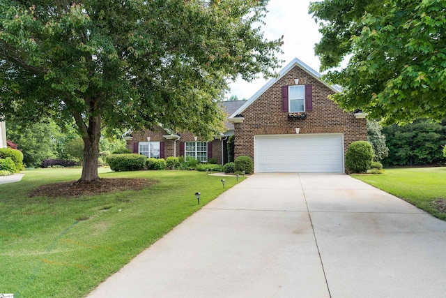 view of front facade featuring brick siding, a front yard, and driveway