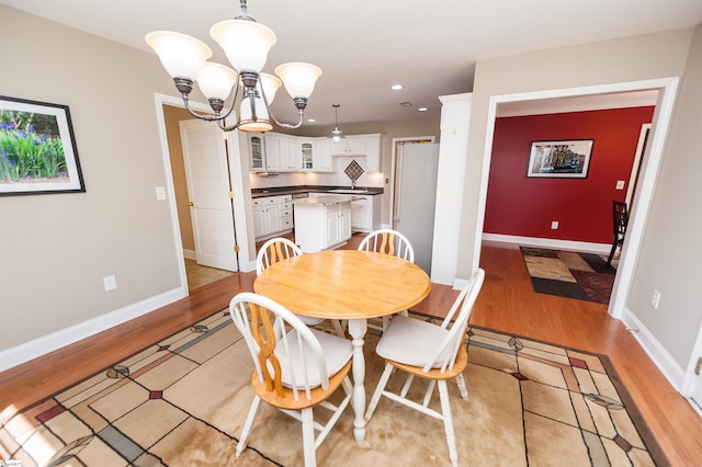 dining room with light wood-style flooring, a chandelier, recessed lighting, and baseboards