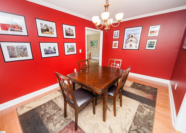 dining space with a chandelier, wood finished floors, crown molding, and baseboards