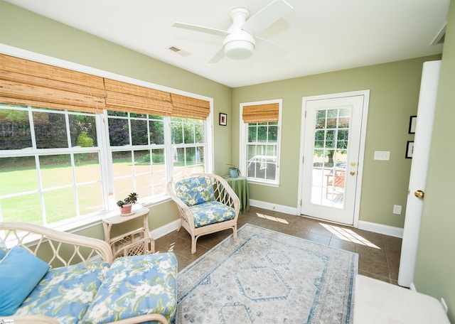 sunroom / solarium featuring tile patterned flooring, plenty of natural light, and a ceiling fan