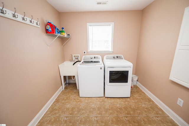laundry room with independent washer and dryer, light tile patterned floors, and baseboards