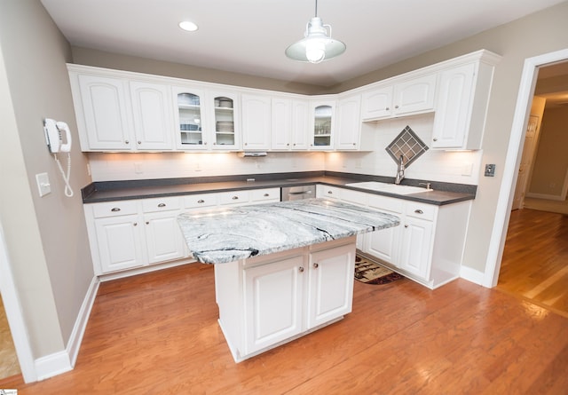 kitchen featuring a sink, tasteful backsplash, light wood finished floors, white cabinetry, and recessed lighting