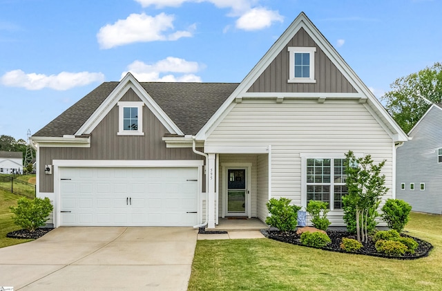 view of front of home with board and batten siding, a front yard, driveway, a garage, and roof with shingles