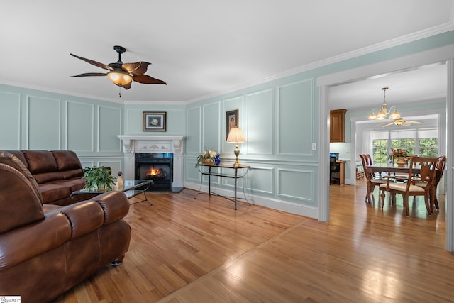 155 Mountain Lake Dr, Piedmont, SC 29673 - living room with a decorative wall, crown molding, a ceiling fan, a chandelier, and a warm lit fireplace