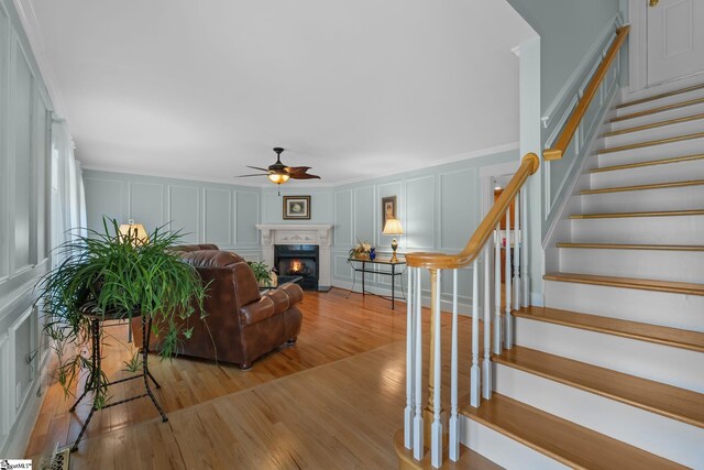 155 Mountain Lake Dr, Piedmont, SC 29673 - living room featuring a decorative wall, a ceiling fan, light wood finished floors, stairway, and a lit fireplace