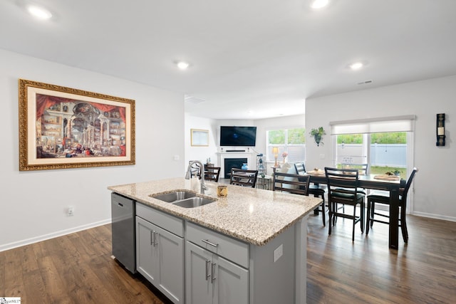 51 Oak Edge Ln, Greer, SC 29651 - kitchen featuring a sink, stainless steel dishwasher, a fireplace, dark wood-style floors, and a center island with sink