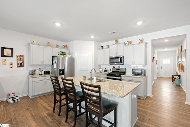 51 Oak Edge Ln, Greer, SC 29651 - kitchen with appliances with stainless steel finishes, a sink, a breakfast bar area, an island with sink, and dark wood-type flooring